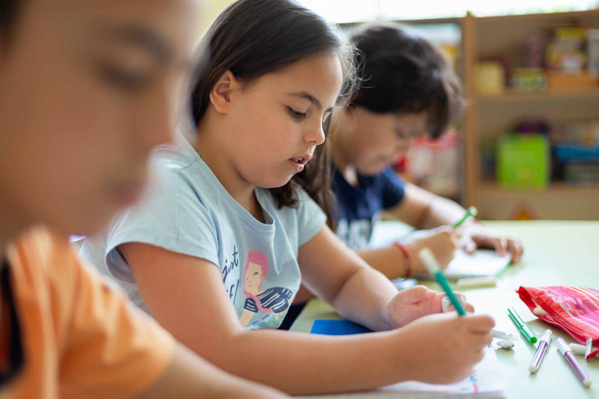 Children learning together at a classroom table, supported with practical behaviour change resources